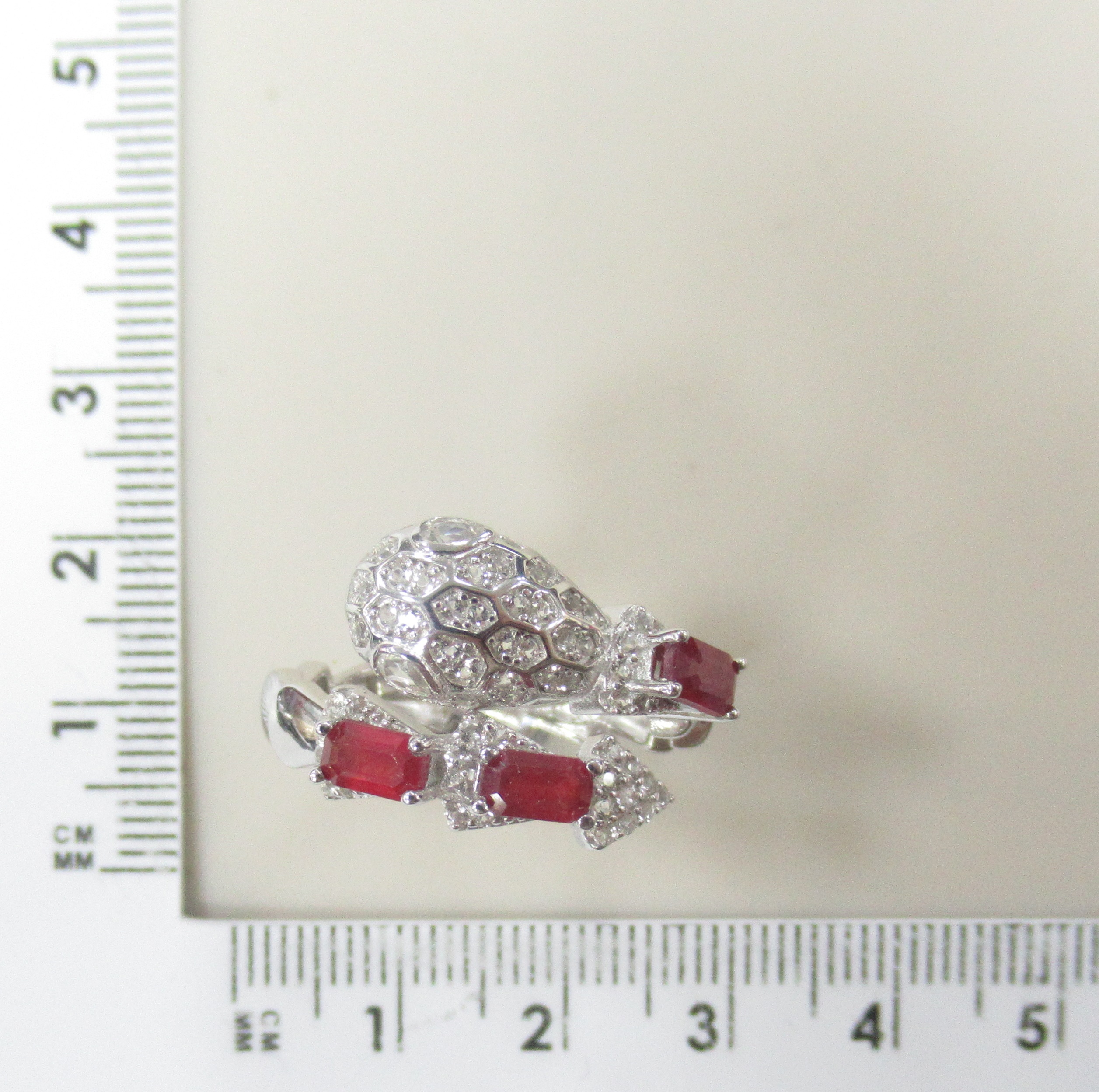 Серебряное кольцо  925 пробы; незамкнутое; вставки 3 Рубин 1,4ct F/2; 64 Топаз белый 0,63ct;